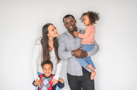 family with boy and girl child posing on photo shooting on white backgroundの写真素材