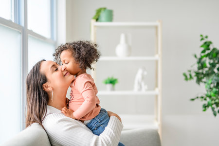 Mother with little daughter at home sofaの写真素材