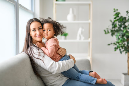 Mother with little daughter at home sofa