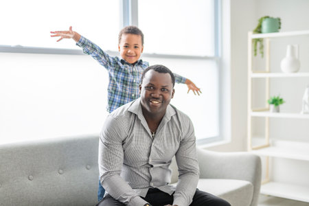 Happy Black American father with little boy at home