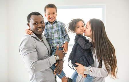 family with boy and girl child posing on photo shooting on white appartement