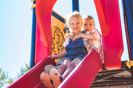 Happy kid slide on playground on summer seasonの写真素材