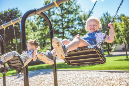 Happy 3 years old girl on a swing. Happy kid on playground