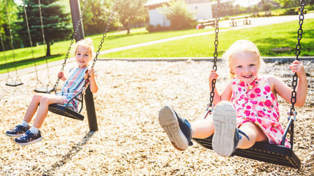 Happy 3 years old girl on a swing. Happy kid on playground