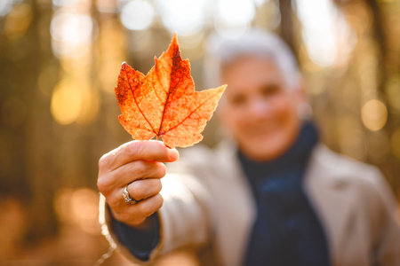 Mature woman in autumn forest, dressed in cozy fall attire, Reflection and connection with nature,...