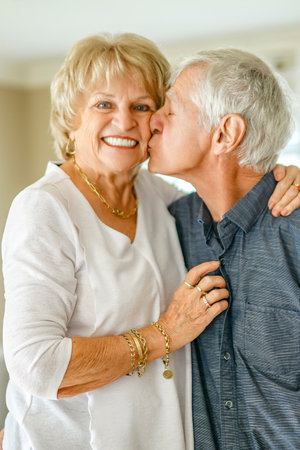 elderly 80s couple embracing each other at home
