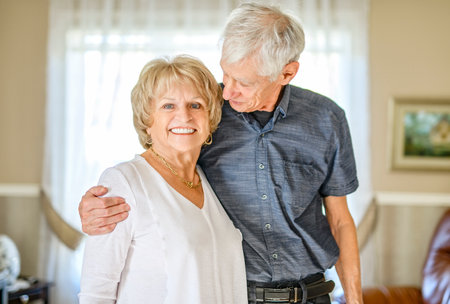 elderly 80s couple embracing each other at home