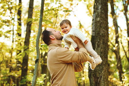 father with baby girl in autumn in beautiful forestの写真素材