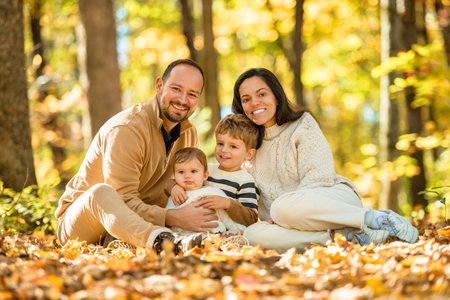 Beautiful young family on a walk in autumn forestの写真素材