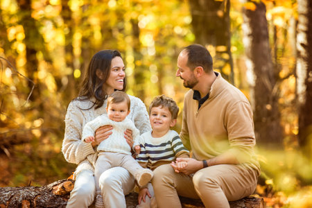 Beautiful young family on a walk in autumn forestの写真素材