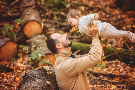 father with baby girl in autumn in beautiful forestの写真素材