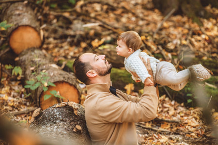 father with baby girl in autumn in beautiful forestの写真素材