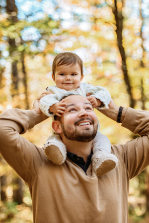 father with baby girl in autumn in beautiful forestの写真素材