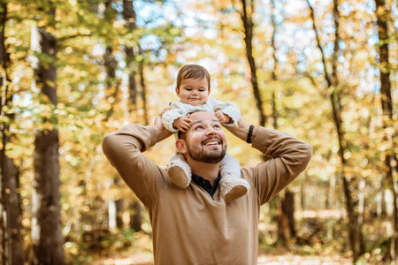 father with baby girl in autumn in beautiful forestの写真素材