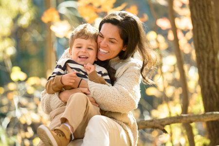 young mother with son in autumn in beautiful forestの写真素材