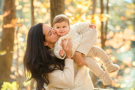 woman with baby girl in autumn in beautiful forest