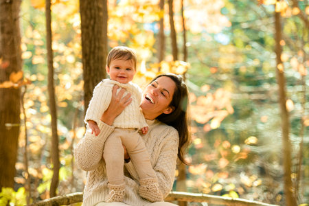 woman with baby girl in autumn in beautiful forestの写真素材