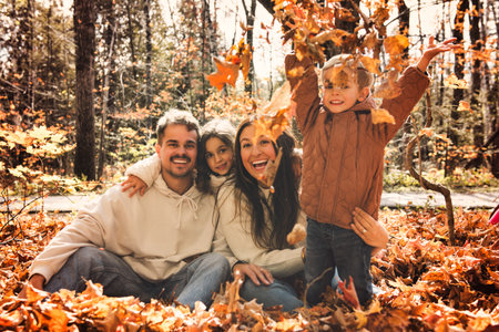 Beautiful young family having great time in autumn forestの写真素材