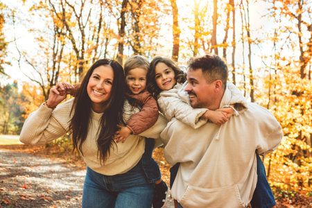 Beautiful young family having great time in autumn forest