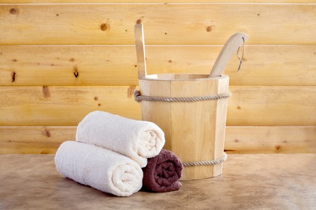 Traditional wooden sauna for relaxation with bucket of water and set of clean towelsの写真素材