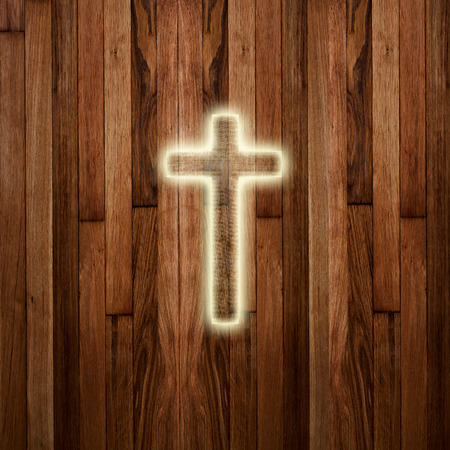Glowing holy cross on abstract wooden backgroundの写真素材