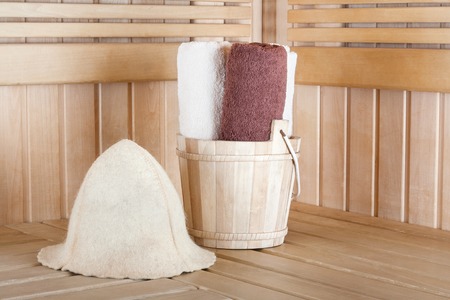 Traditional wooden sauna for relaxation with bucket of water and set of clean towelsの写真素材