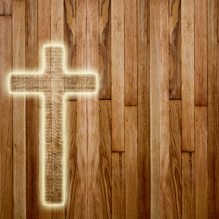 Glowing holy cross on abstract wooden backgroundの写真素材