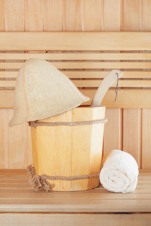 Traditional wooden sauna for relaxation with bucket of water and set of clean towelsの写真素材