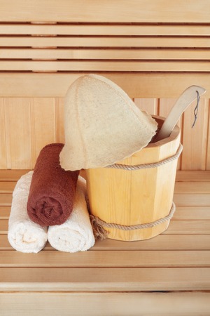 Traditional wooden sauna for relaxation with bucket of water and set of clean towelsの写真素材