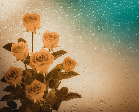 Bouquet of red roses on the background of a window with raindropsの写真素材