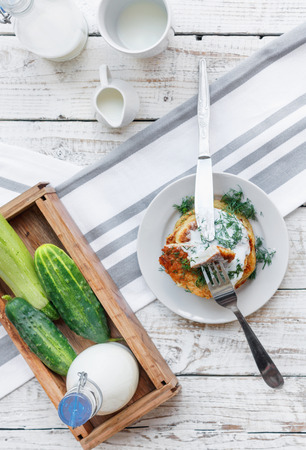 Delicious pancakes from courgettes and fresh vegetables with sour cream and dill on the table top viewの写真素材