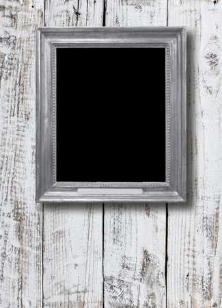 Old vintage silver ornate frame for picture on grunge wooden wallの写真素材