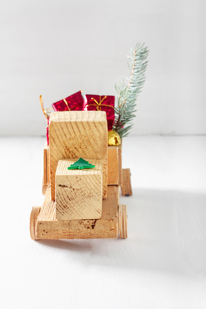 Old vintage toy wooden car with gifts and Christmas balls on white backgroundの写真素材