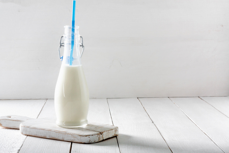 Old  vintage style bottles with fresh milk on grunge white wooden table.の写真素材