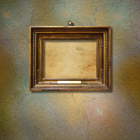 Old vintage gold ornate frame for picture on grunge stone wall