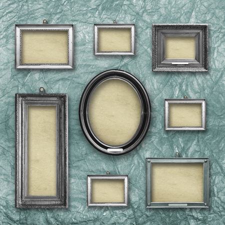 Set of wooden vintage silver  modern,  frames for museum exhibition on old, worn green wall