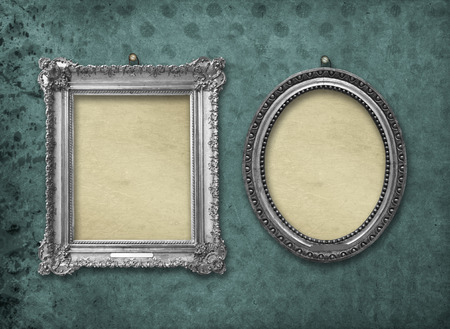 Set of wooden vintage silver victorian frames for museum exhibition on old, worn green wall