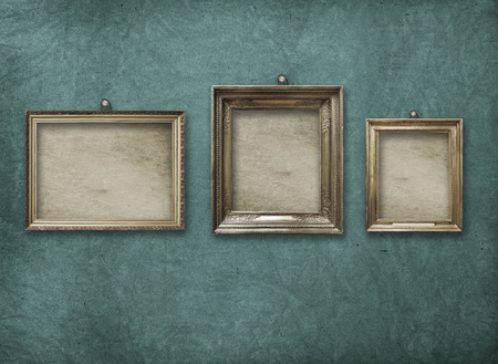 Old vintage gold ornate frame for picture on grunge stone wall