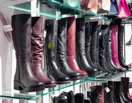 Shelves with beautiful fashionable leather shoes and bags in storeの写真素材