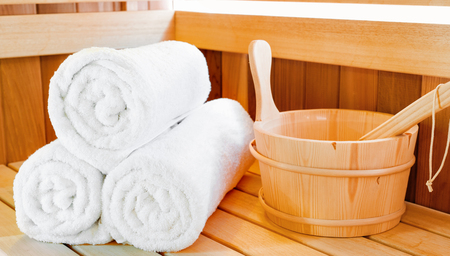 Traditional classic wooden sauna for relaxation with bucket of water and set of clean towelsの写真素材