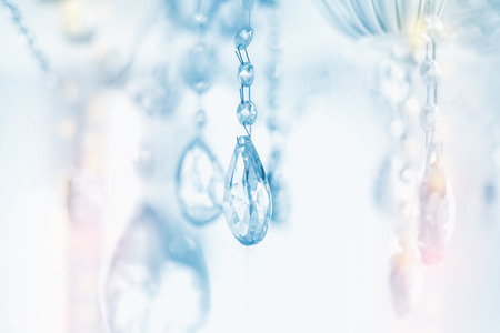 Beautiful multicolored light reflecting through brushed  glass crystals hanging on vintage chandelierの写真素材