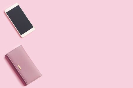 Beautiful delicate pink background with glamour leather wallet and new smartphone. Flat lay Top view with copy space for  your text.の写真素材