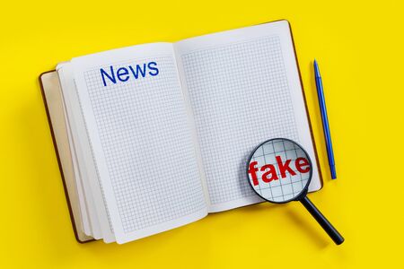 Open empty notebook with magnifier for fake news on yellow background in style of Zine. Top view flat lay copy space.の写真素材