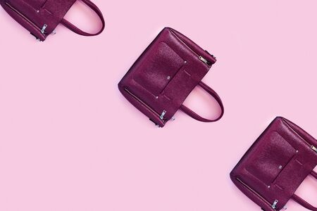 Beautiful leather purple handbags on a pink paper background  in zine style. Top view, flat lay, copy space concept.の写真素材