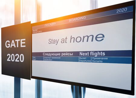Text with social inscription on the airport board: stay home, during the coronavirus pandemic....