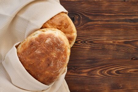 Fresh homemade wheat bread on  wooden table.  Flat lay, top view, copy space concept.