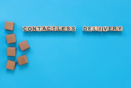 Cardboard boxes with groceries or other purchases on  blue background. The inscription on wooden...
