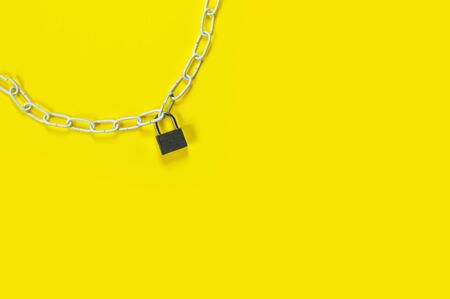 Large metal padlock on a bright yellow background.
Flat lay, top view, copy space concept.の写真素材