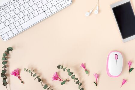 Top view of home office desk with laptop, notebook, headphones, computer mouse and  and eucalyptus and weigela on yellow paper background. 
Flat lay, top view, copy space concept.の写真素材