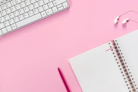 Top view of white home office desk with laptop, notebook and headphones on pink paper background. 
Flat lay, top view, copy space concept.の写真素材